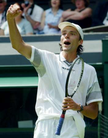 Ivo Karlovic of Croatia serves to defending Champion Lleyton Hewitt during their Men's Singles, First Round match on the Centre Court, on the first day of the All England Lawn Tennis Championships at Wimbledon , Monday June 23, 2003. Karlovic defeated the defending champion 1-6, 7-6 (7-5), 6-3, 6-4. (AP Photo/Dave Caulkin)